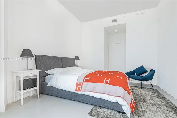 a bedroom with a bed and a chair