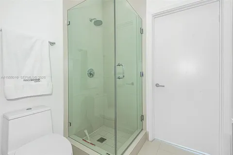 a bathroom with a shower a toilet and a sink