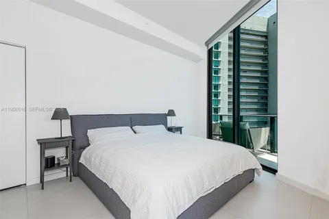 a large bed sitting in a bedroom next to a window