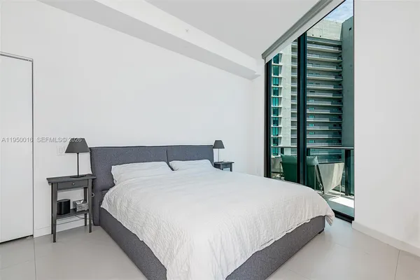 a large bed sitting in a bedroom next to a window