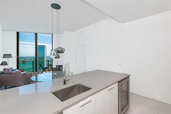 a kitchen with a sink and living room view