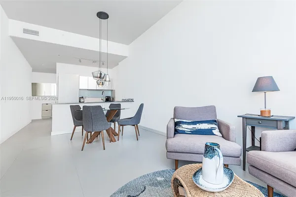 a living room with furniture and a dining table