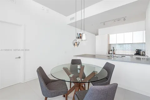 a kitchen with a dining table chairs and white cabinets