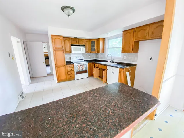 a kitchen with stainless steel appliances granite countertop a sink refrigerator and cabinets