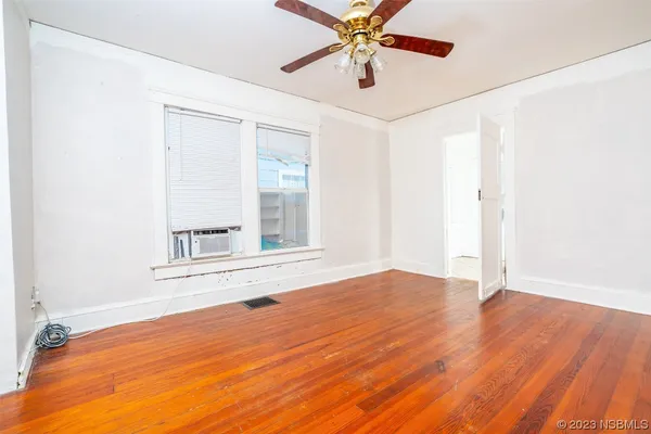 wooden floor in an empty room with a window