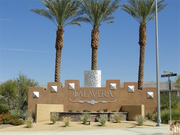 a front view of a building with sign board and palm trees