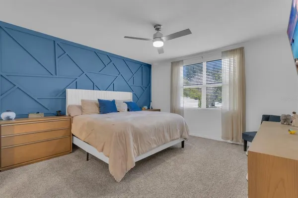 a bedroom with a bed and a ceiling fan