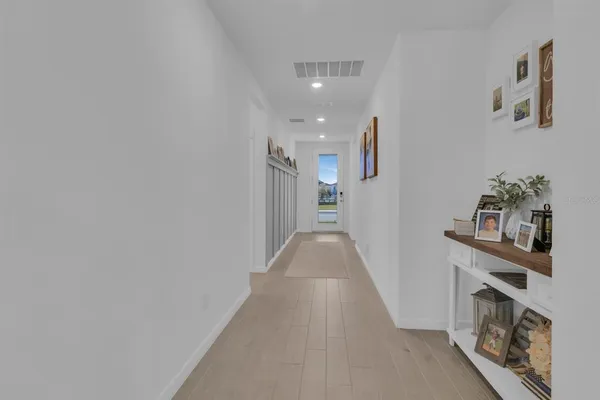 a view of a hallway with wooden floor and staircase