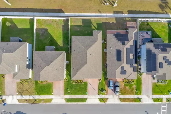 an aerial view of residential houses with outdoor space and swimming pool