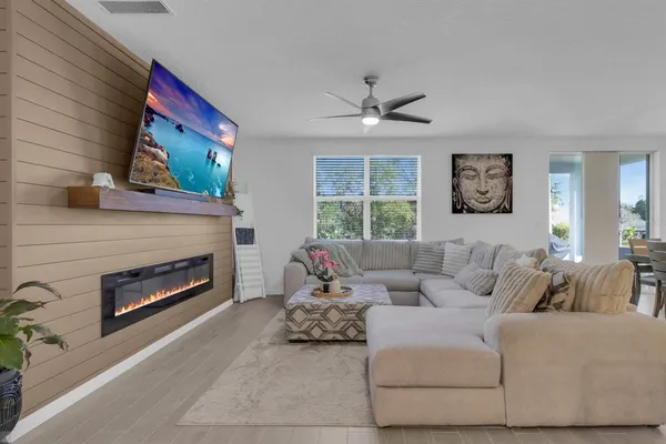 a kitchen with stainless steel appliances a dining table chairs refrigerator and microwave