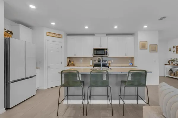 a living room with furniture and kitchen view