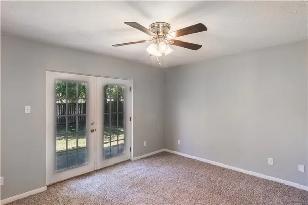 an empty room with window and ceiling fan