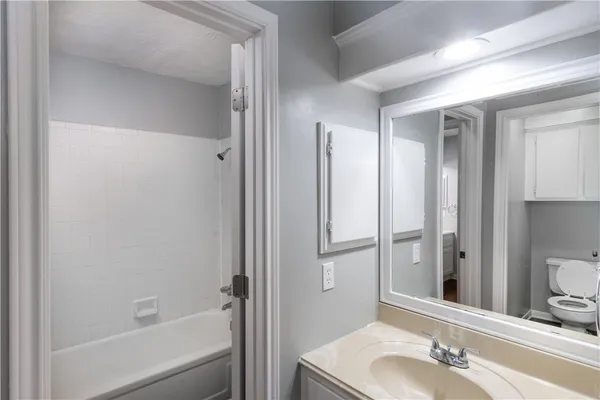 a bathroom with a tub shower and sink