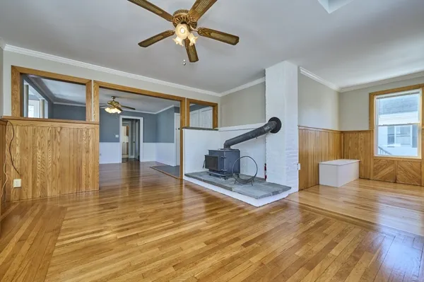 a living room with couches and kitchen view with wooden floor