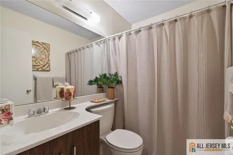 a bathroom with a sink a toilet and shower curtain