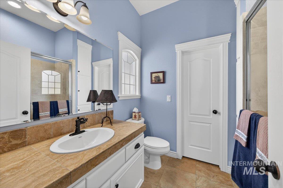 414 East Shafer View Drive Meridian, ID 83642 - Photo 26 of 50 Full Bathroom has spacious vanity with an oval sink, dark bronze faucet, and tiled countertop, Step In Tiled Shower w/Glass Door, Walk-in Closet & Separate Linen storage Closet