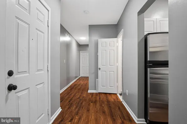 a view of a hallway with wooden floor and closet