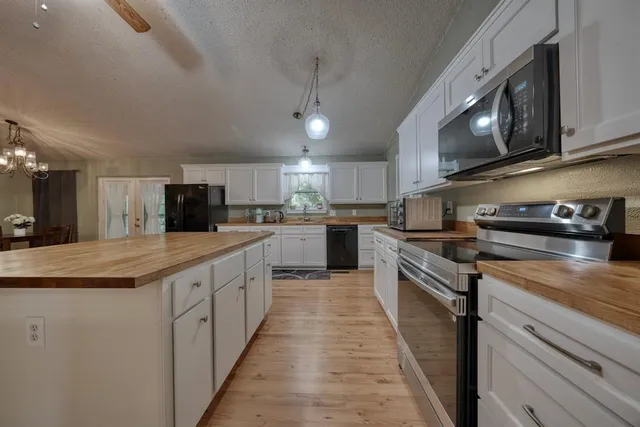 a kitchen with a sink a microwave and cabinets