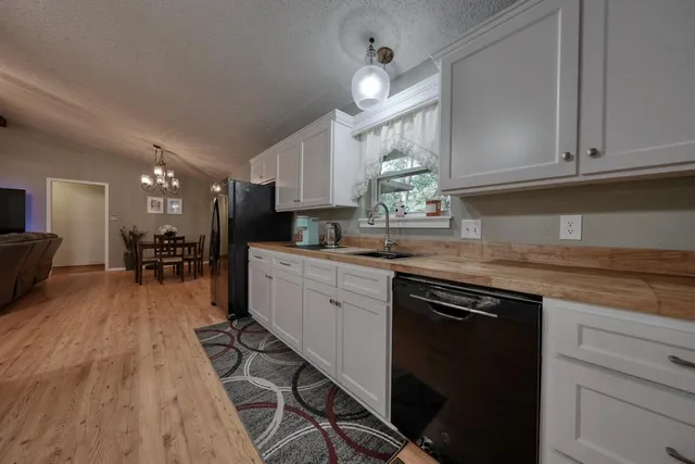 a dining room with furniture a chandelier and wooden floor