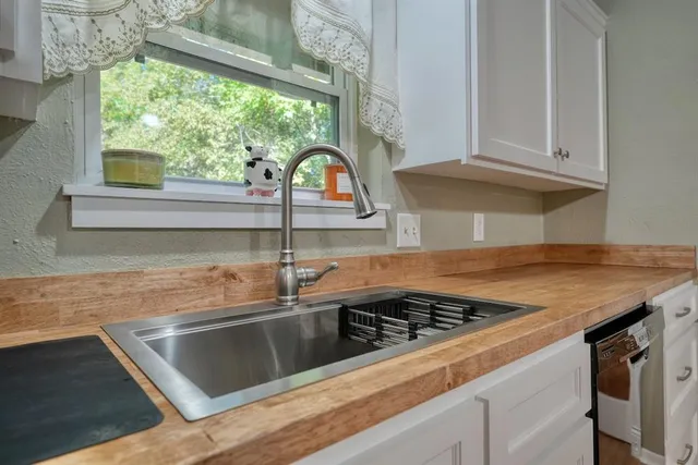 a spacious bathroom with a granite countertop sink a toilet a mirror and shower