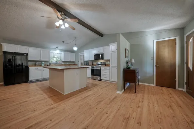 a view of kitchen with refrigerator microwave and wooden floor