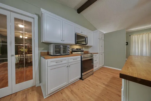 a kitchen with a sink a microwave and cabinets