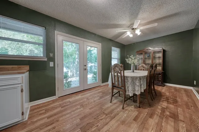 a dining room with furniture a chandelier and wooden floor