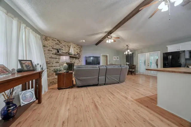 a large white kitchen with wooden floors and a fireplace
