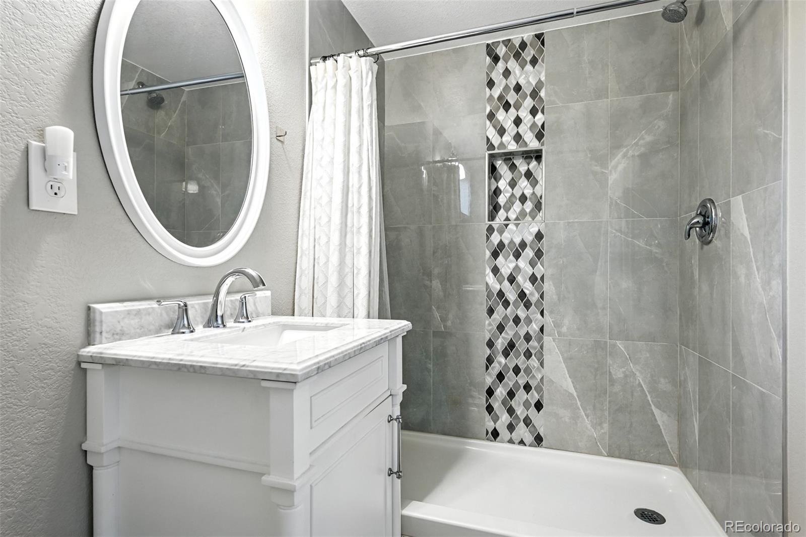 2714 South Raleigh Street Denver, CO 80236 - Photo 28 of 34 a bathroom with a sink a toilet and a mirror