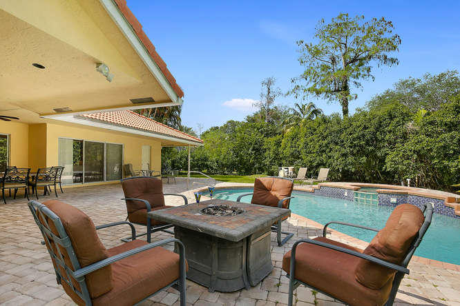 9497 Old Pine Road Boca Raton, FL 33428 - Photo 20 of 31 a view of a patio with a dining table and chairs with potted plants