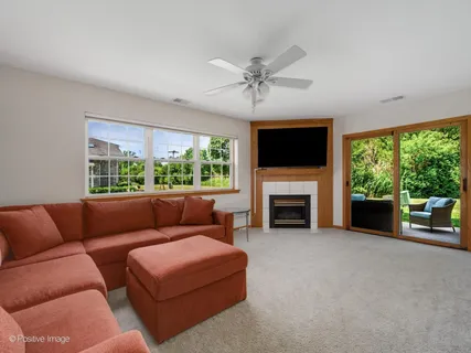 a living room with furniture a large window and a fireplace