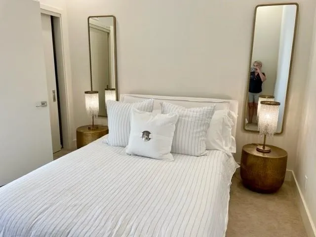 a bedroom with a bed a mirror and a lamp