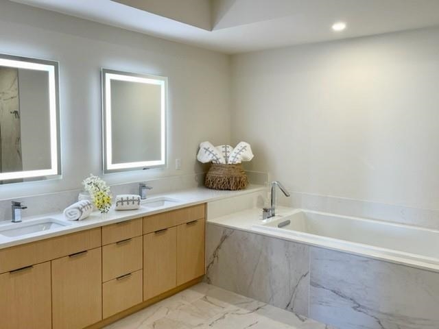161 Holomoana Way, Unit 102 Kihei, HI 96753 - Photo 24 of 34 a bathroom with a double vanity sink and mirror