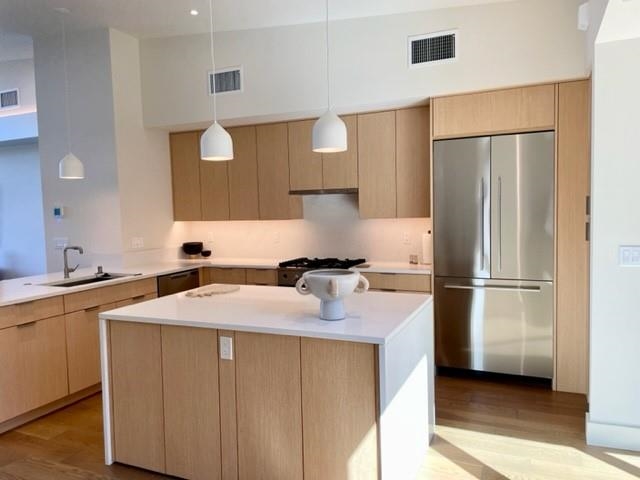 161 Holomoana Way, Unit 102 Kihei, HI 96753 - Photo 8 of 34 a kitchen with a sink a refrigerator a washer and dryer
