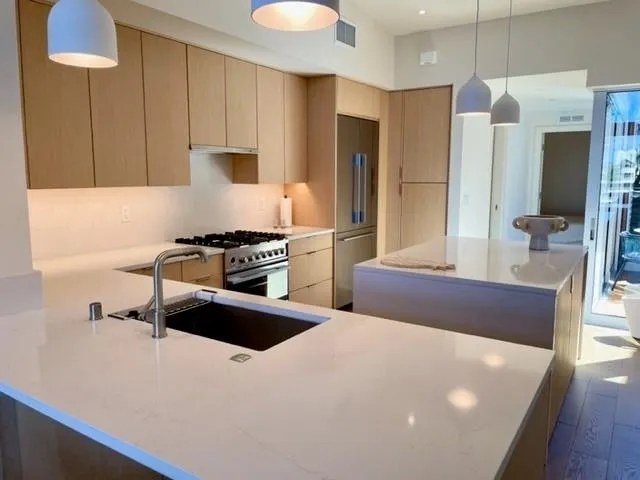 a kitchen with stainless steel appliances a sink stove and refrigerator