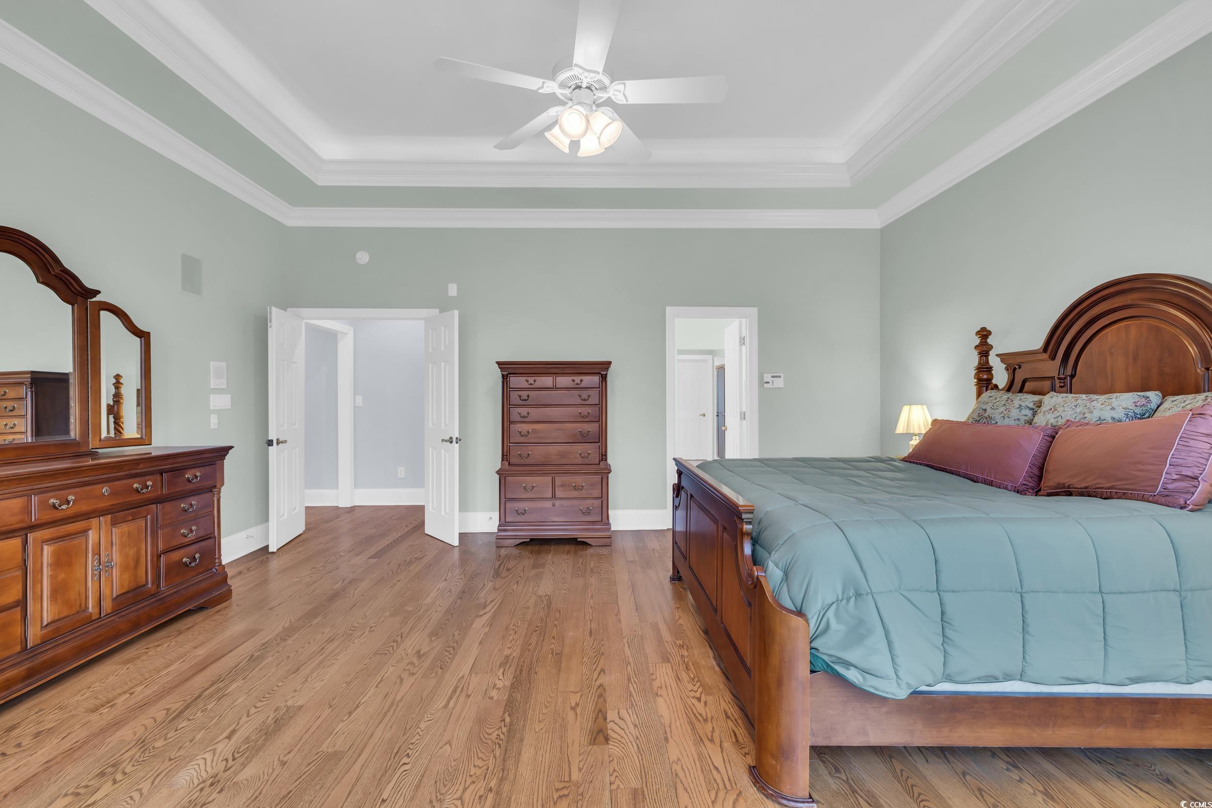 1473 Doar Point Myrtle Beach, SC 29577 - Photo 11 of 40 Bedroom with ornamental molding, light wood-type flooring, ceiling fan, and a tray ceiling