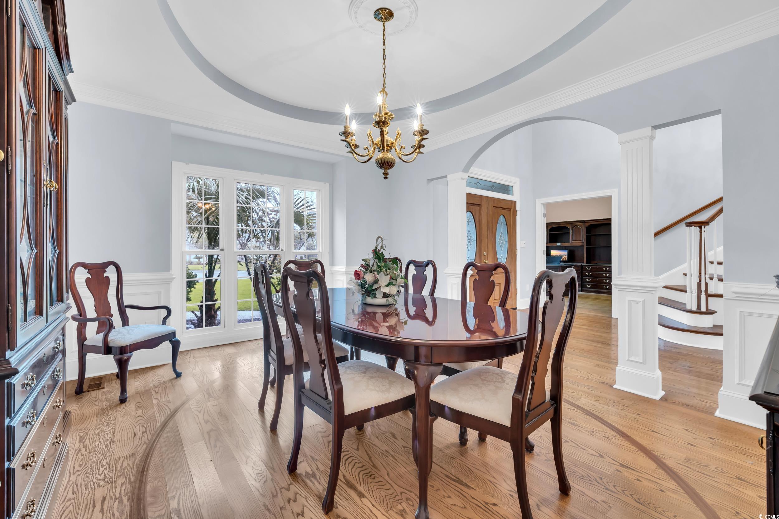1473 Doar Point Myrtle Beach, SC 29577 - Photo 17 of 40 Dining room with a decorative wall, decorative columns, a wainscoted wall, arched walkways, and ornamental molding