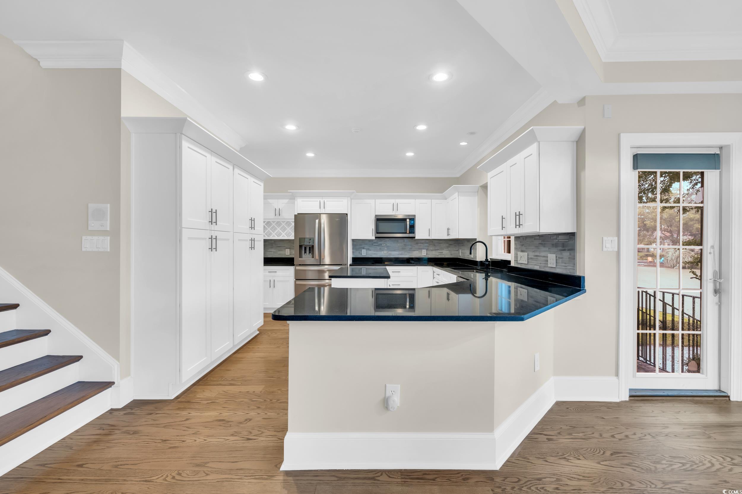 1473 Doar Point Myrtle Beach, SC 29577 - Photo 23 of 40 Kitchen featuring ornamental molding, backsplash, dark countertops, a peninsula, and recessed lighting