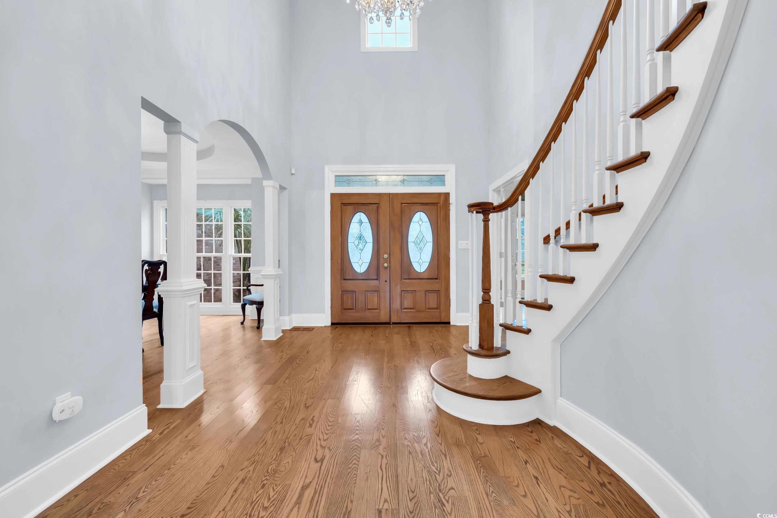 1473 Doar Point Myrtle Beach, SC 29577 - Photo 3 of 40 Foyer entrance with wood finished floors, arched walkways, ornate columns, a towering ceiling, and stairway