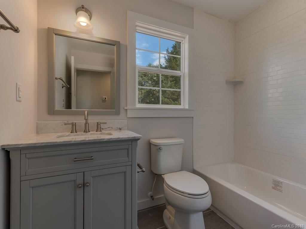 4924 Hudlow Road Union Mills, NC 28167 - Photo 11 of 34 a bathroom with a granite countertop toilet a sink and a bathtub
