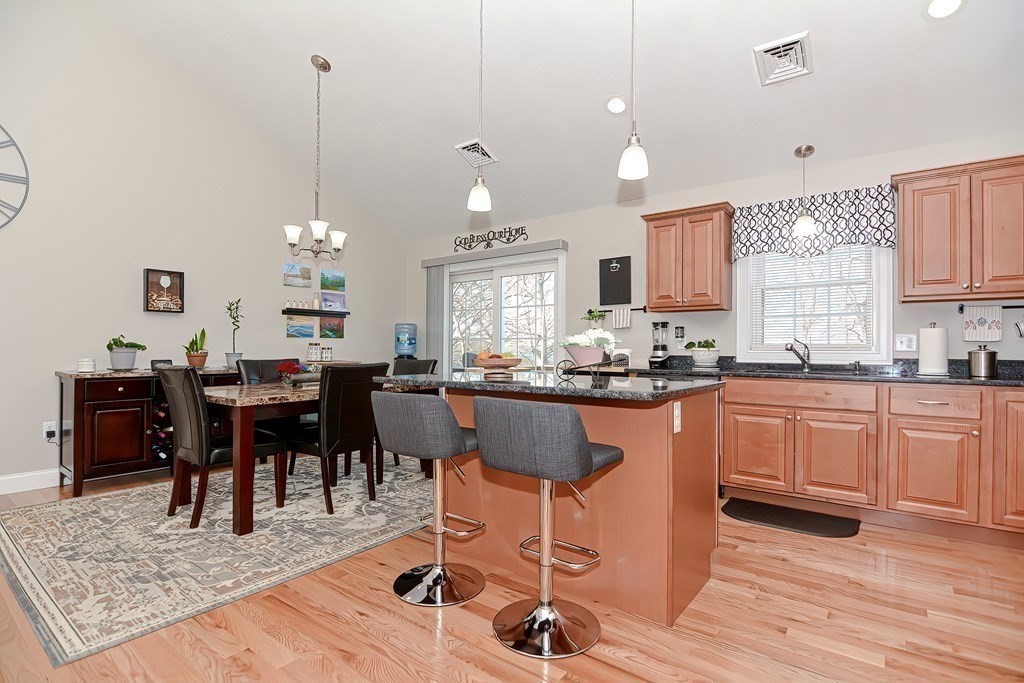 1066 Spencer Street Fall River, MA 02721 - Photo 5 of 35 a kitchen with stainless steel appliances granite countertop a stove a sink dishwasher a dining table and chairs with wooden floor