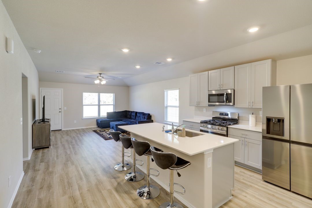 2003 Buckland Hollow Trail Spring Spring, TX 77373 - Photo 4 of 9 a kitchen with a refrigerator a stove a sink dishwasher a oven with white cabinets and wooden floor
