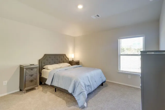 a bedroom with a bed and a window