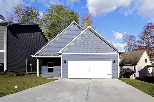 a view of a house with a yard and potted plants