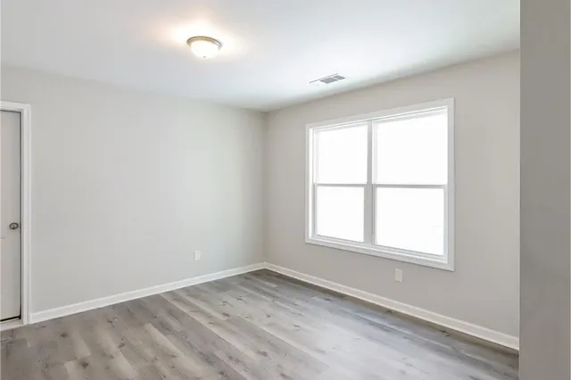 a view of an empty room with wooden floor