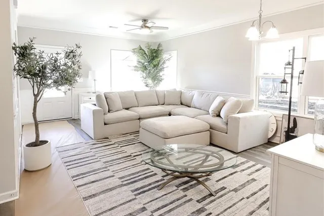 a living room with furniture and a chandelier
