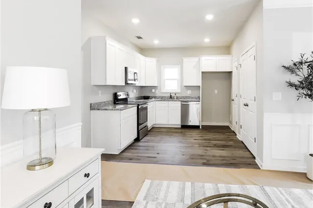 a kitchen with stainless steel appliances granite countertop a refrigerator a stove and a sink