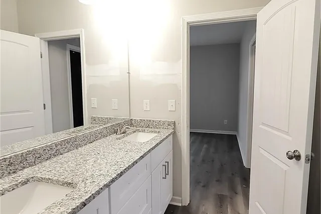 a bathroom with a granite countertop sink and a mirror