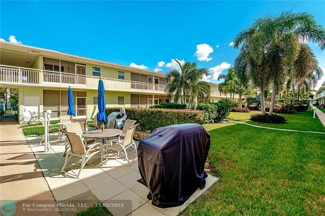 a view of a patio with table and chairs potted plants and palm trees