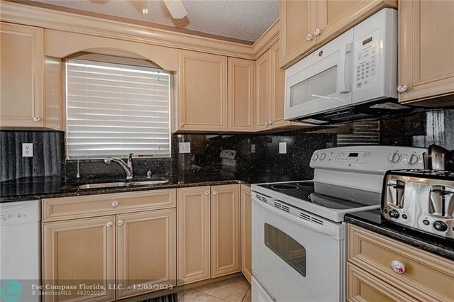 a kitchen with white cabinets and appliances